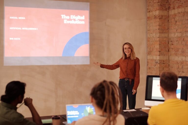 Professora apresenta tema sobre inteligência artificial e evolução digital para estudantes universitários em sala de aula, destacando o impacto da IA na educação.